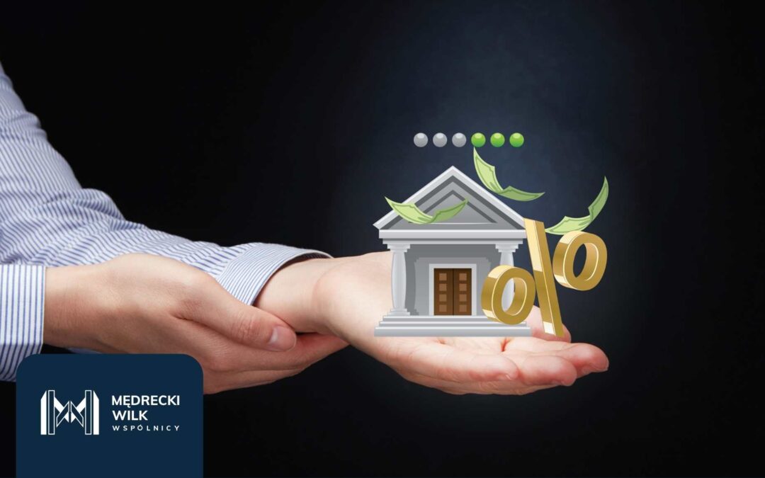 Wizualizacja banku i symbolu procentu na dłoniach – unieważnienie kredytu frankowego z pomocą kancelarii Mędrecki Wilk i Wspólnicy
